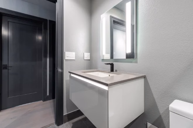 A bathroom sink with a newly painted door in the background