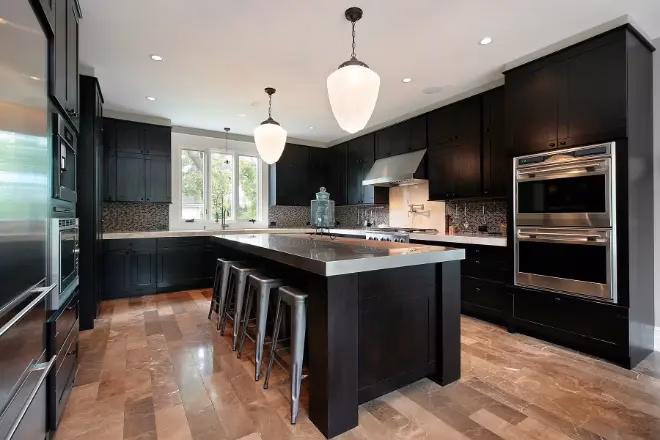 A kitchen island with stainless steel countertop and dark wood cabinets