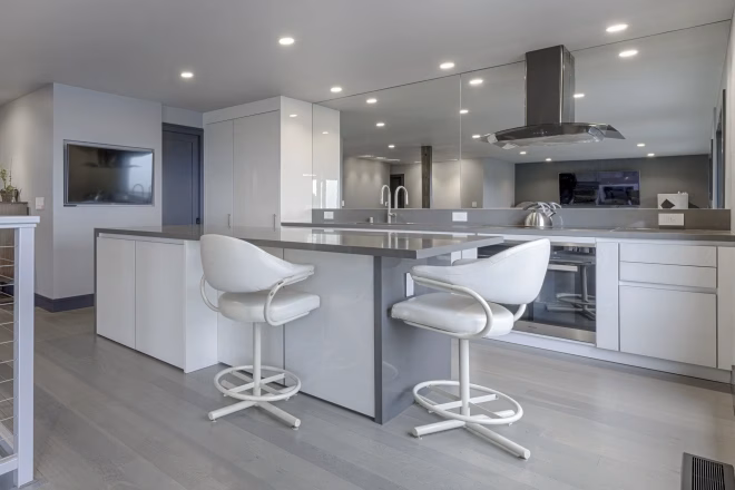 A kitchen remodeled by Home Pride Construction that features island seating and sleek white cabinets