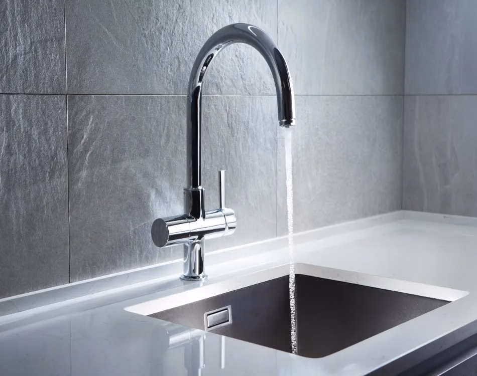 A new silver kitchen faucet with the water on.