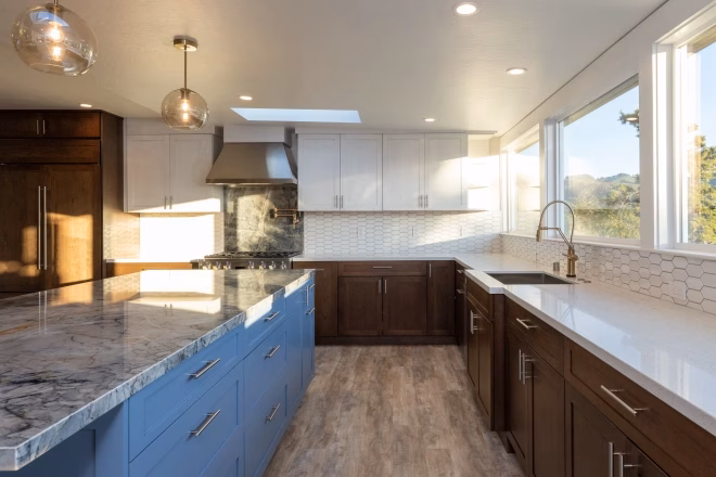 A newly remodeled kitchen featuring a kitchen island with a granite countertop and blue cabinets underneath