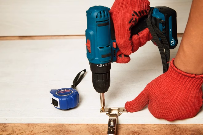 Installation of furniture hinges in the kitchen cabinet door. Tools and furniture fittings needed to replace hinges.