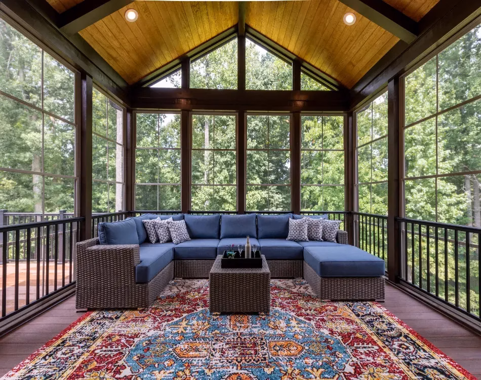 New modern screened porch with patio furniture, summertime woods in the background