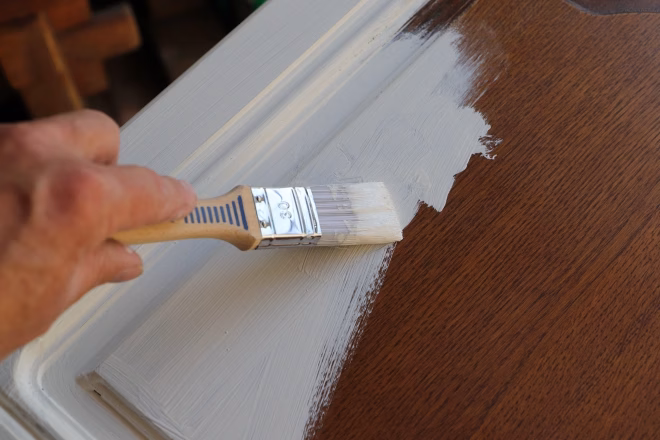 a brown kitchen cabinet is painted with white chalk paint
